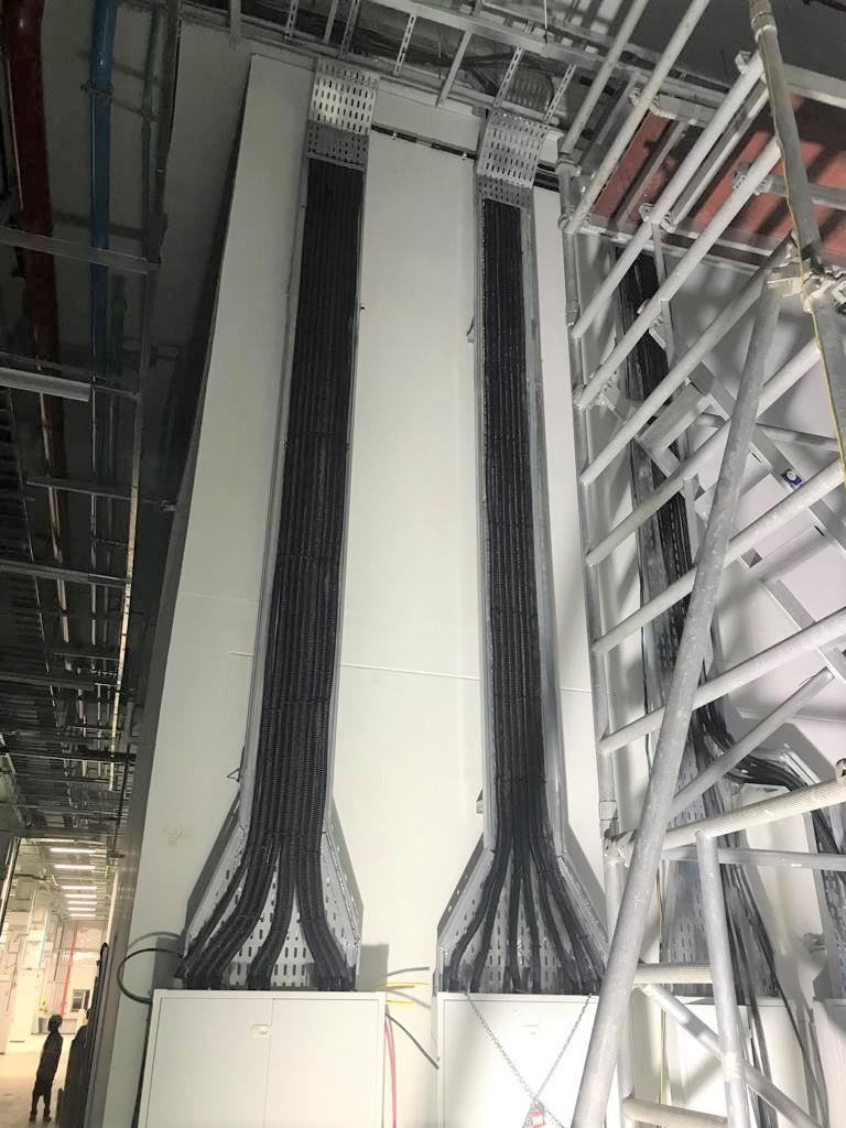 Electrical cabling routed through cable trays inside a commercial building shaft